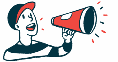 A person in a baseball cap speaks into a megaphone.