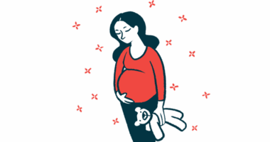 A pregnant woman stands holding a stuffed toy and cradling her belly.