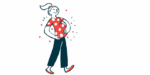 A woman smiles as she walks and cradles her baby bump.